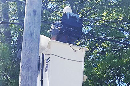 service technician in bucket truck working on a cable line